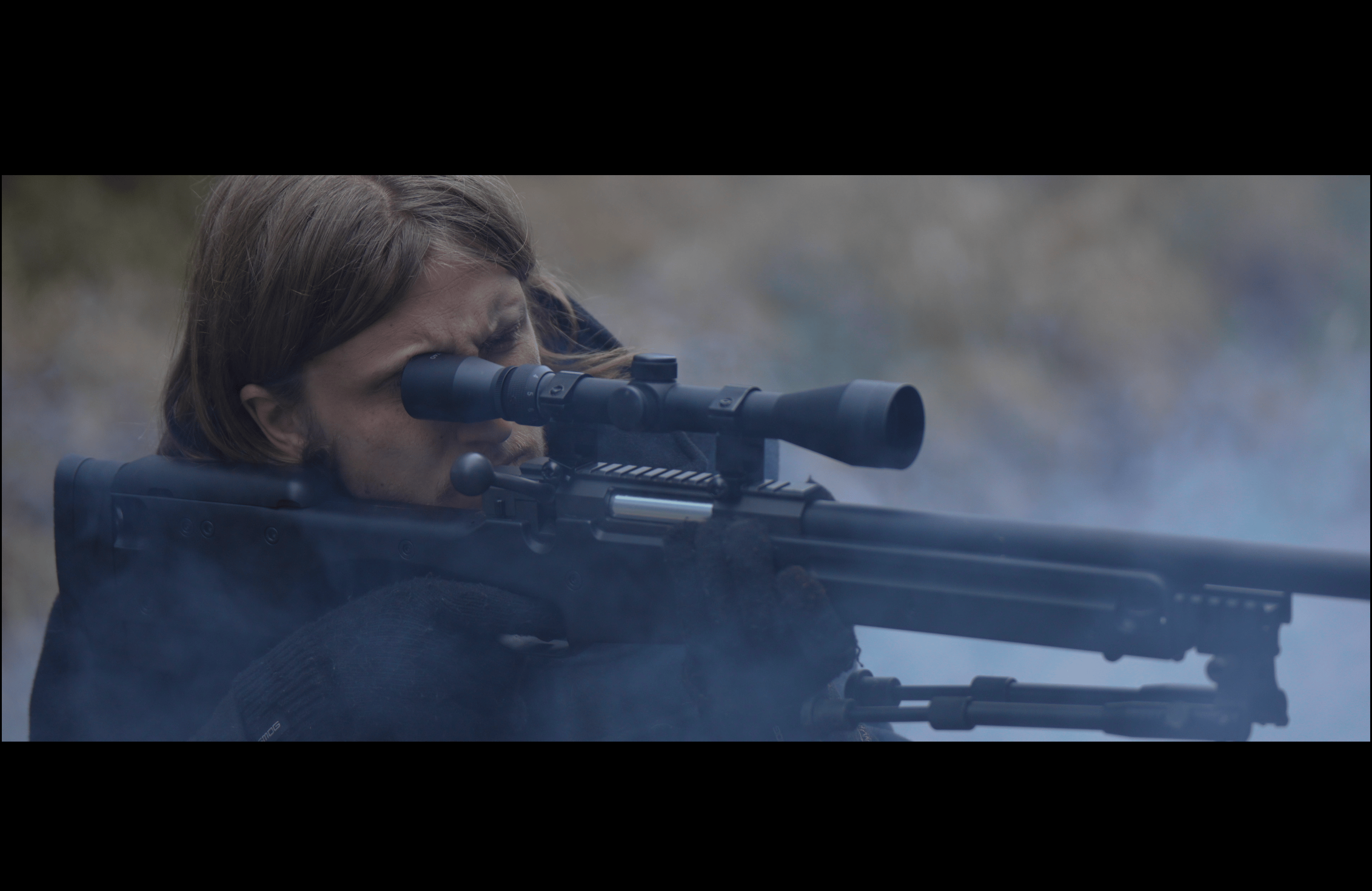 A sniper watches through the wilderness